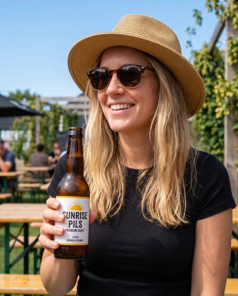 Praxisbeispiel: Person mit Bierflasche im Biergarten bei Sonnenschein